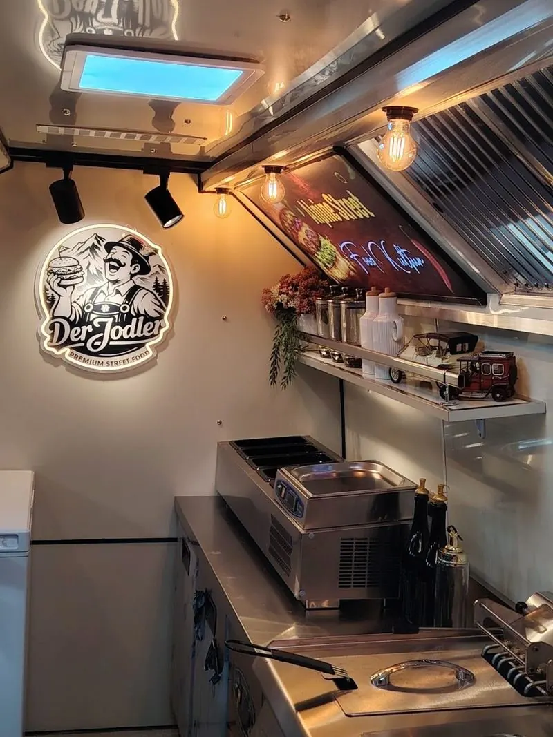 Food truck içinde neon tabelalı, aydınlatmalı paslanmaz mutfak