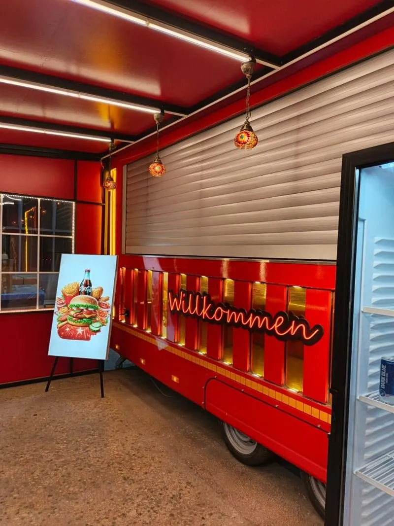 Red lit interior with a roller shutter and serving counter