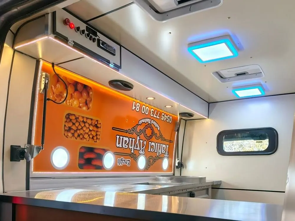 Stainless counter and lit interior of a lokma dessert van
